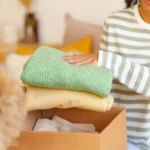 How to store clothes safely at Locked Self Storage Alloa, folding clean clothing into a storage box before placing items in secure indoor storage units.