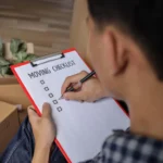 Over shoulder view of a man looking over his shoulder at a moving house checklist created by locked self storage alloa