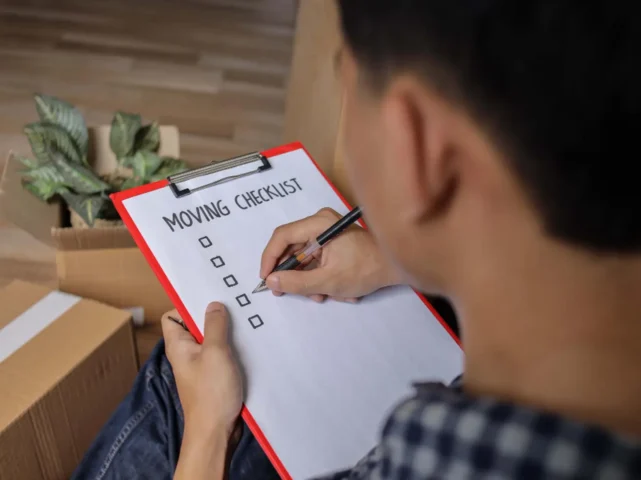 Over shoulder view of a man looking over his shoulder at a moving house checklist created by locked self storage alloa