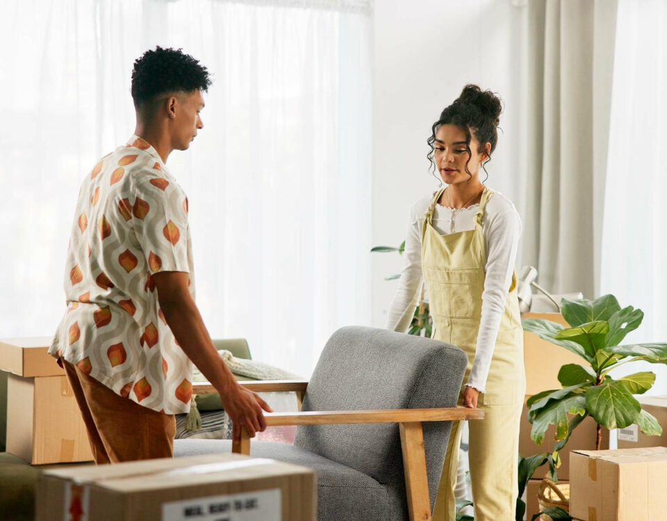 Couple preparing furniture for temporary furniture storage during a delayed house move before moving into their new home.